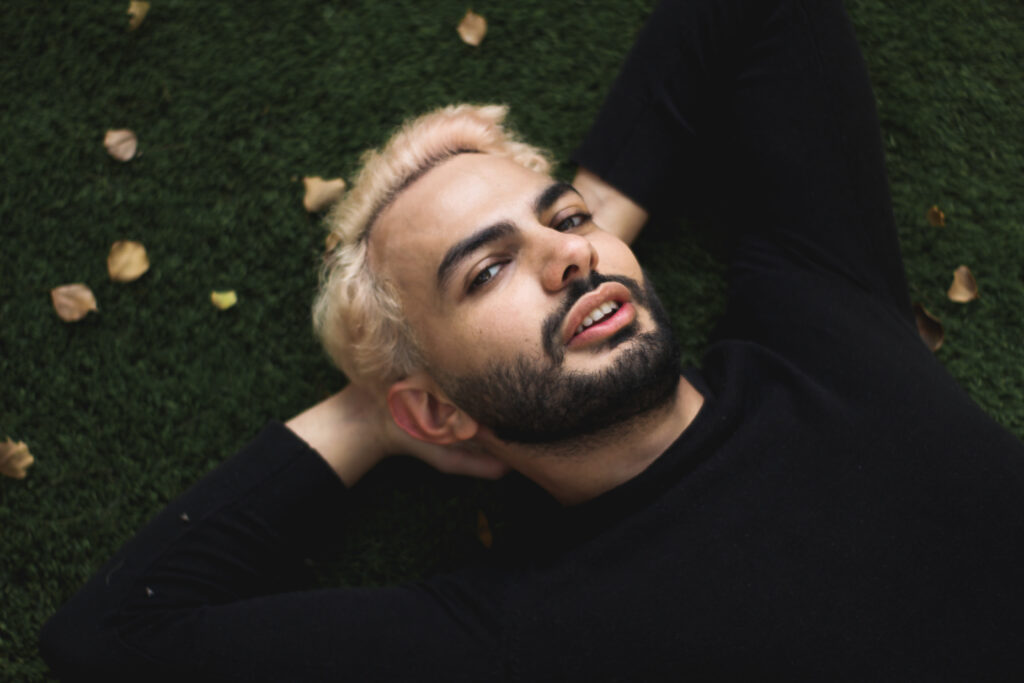 photo de l'artiste Mic Owl. Il est allongé sur l'herbe regardant l'objectif.