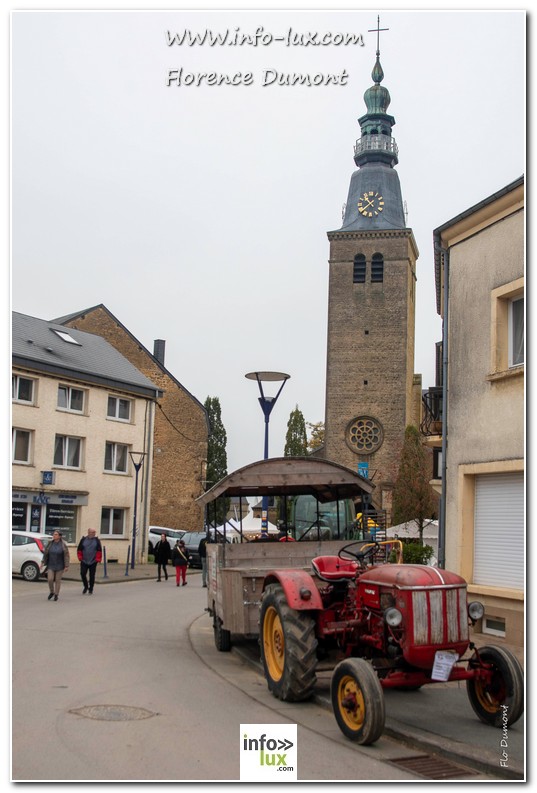 Un vieux tracteur rouge devant l’église de Florenville pendant la Fête de la pomme de terre 2024