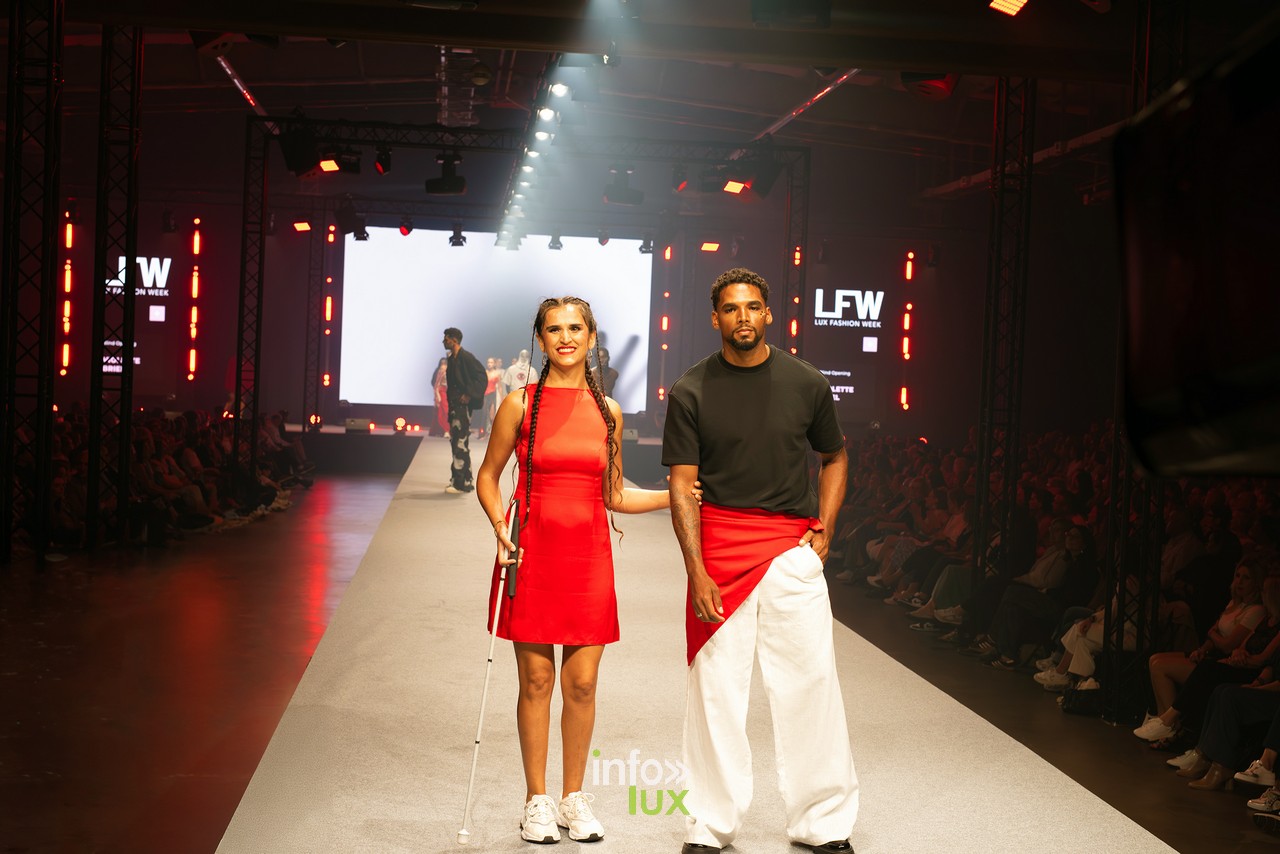 Mannequin malvoyante en robe rouge avec canne blanche accompagnée d'un mannequin masculin, collection inclusive Violette Briel, Lux Fashion Week Arlon