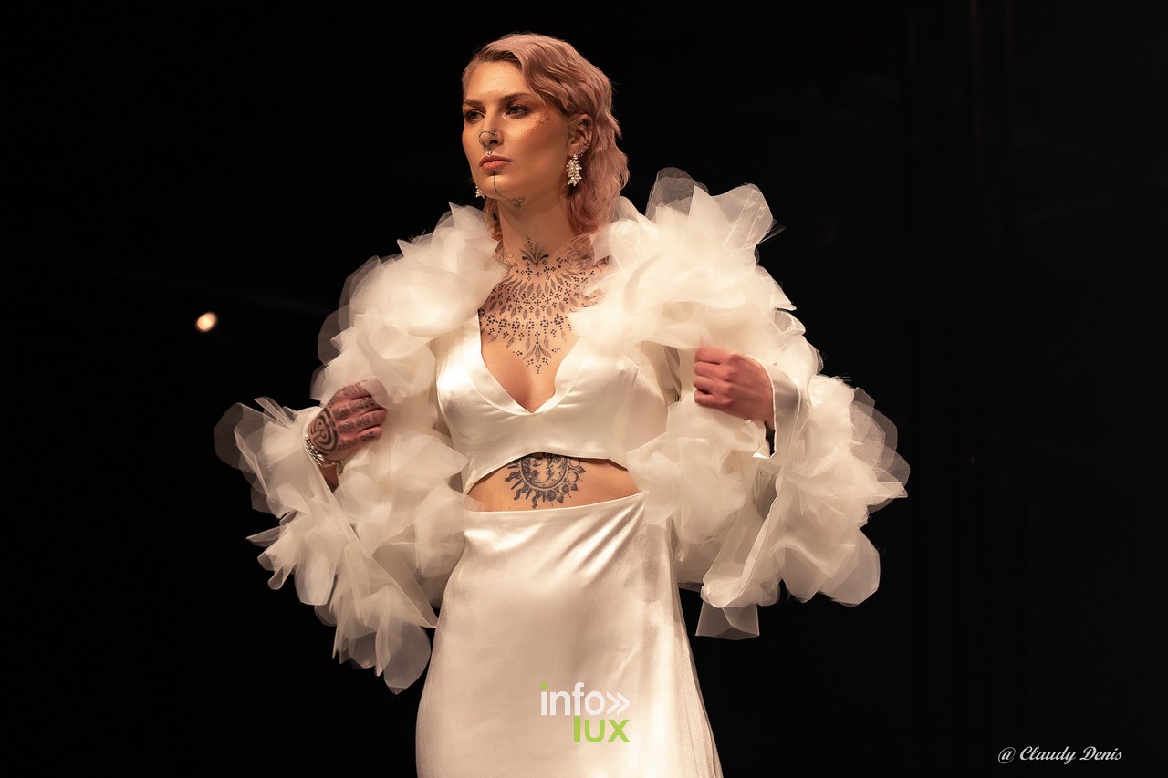 Mannequin en robe blanche à volants de tulle sur le podium de la Lux Fashion Week à Arlon