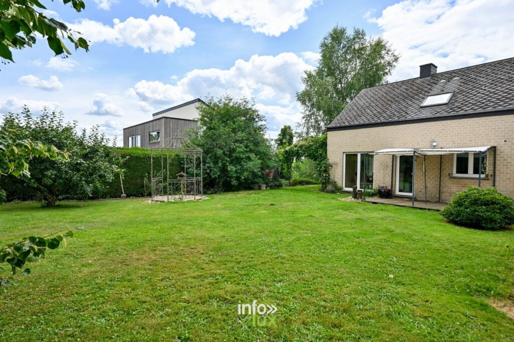 Vue latérale de la maison 4 façades à vendre à Marbehan Habay — accès garage et grand espace