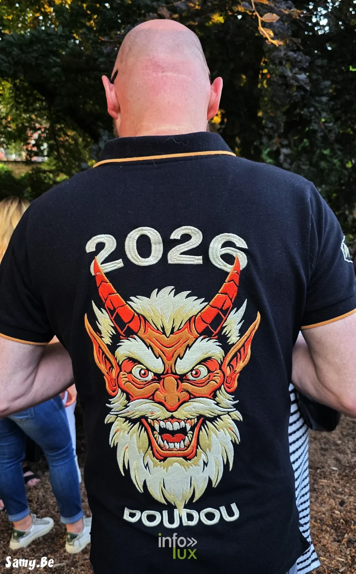 Groupe en bérets rouges et tenues blanches affichant les couleurs de Mons au Doudou 2026
