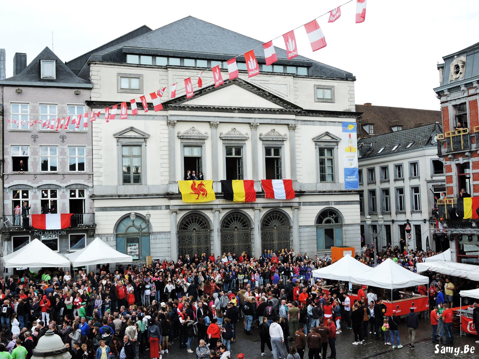 Foule en rouge et blanc accompagnant la Procession du Car d'Or a Mons