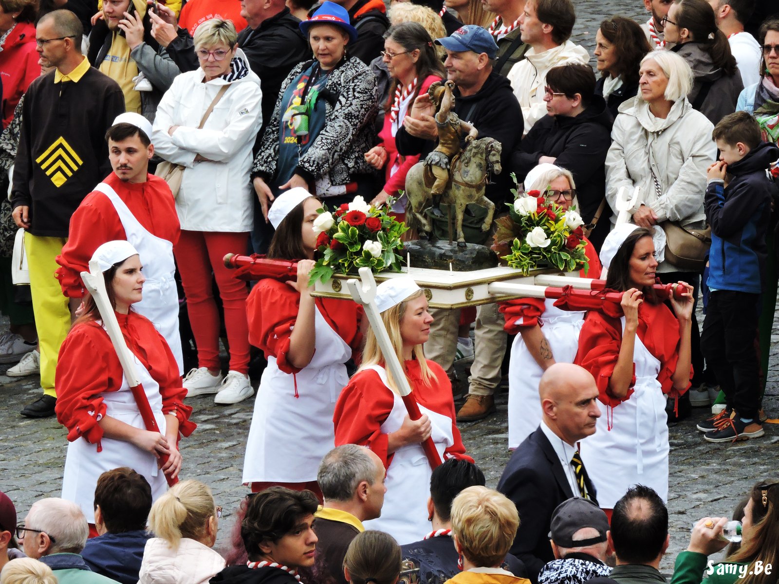 Porteurs en costume rouge et blanc transportant un reliquaire pendant la Procession du Car d'Or