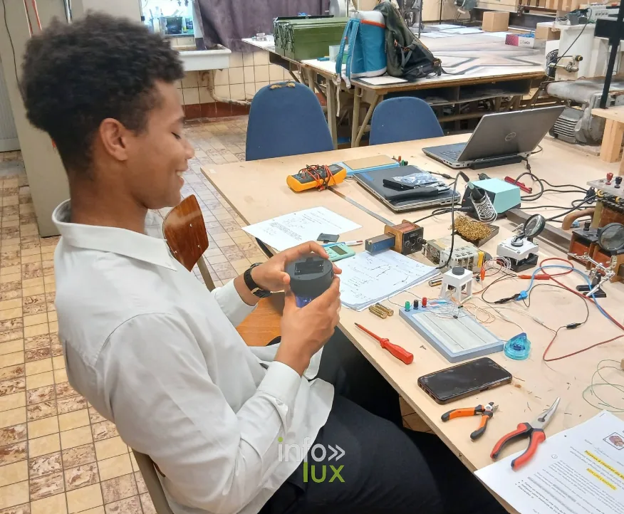 Élève de la section Électricien industriel de l’Athénée Royal d’Athus au travail sur son montage, multimètre en main