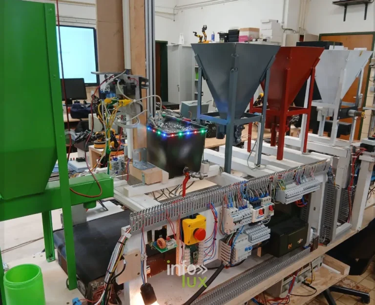 Ligne automatisée complète (trémies de tri, convoyeur, bornier de relais, arrêt d’urgence) — examen de la section Électricien industriel, Athénée Royal d’Athus