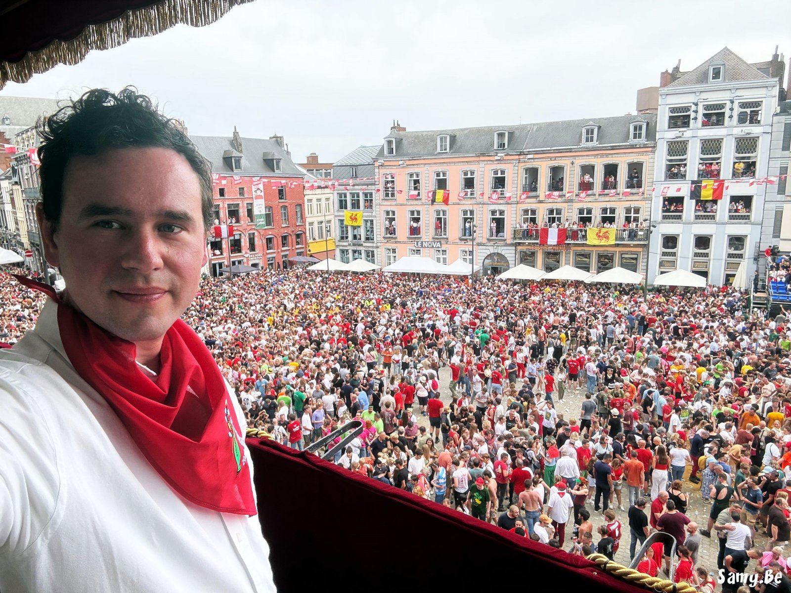 David Leys, invité d'info-lux, découvre le Doudou depuis un balcon de la Grand-Place de Mons
