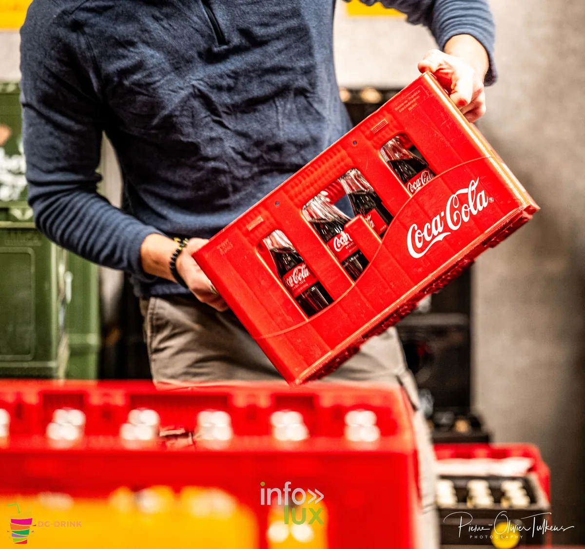 Employé DG Drink portant un casier de Coca-Cola, distribution de boissons en Brabant wallon