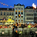 Jets de flammes au-dessus de la foule de la Doudou Sound Party 2026 au crépuscule sur la Grand-Place de Mons