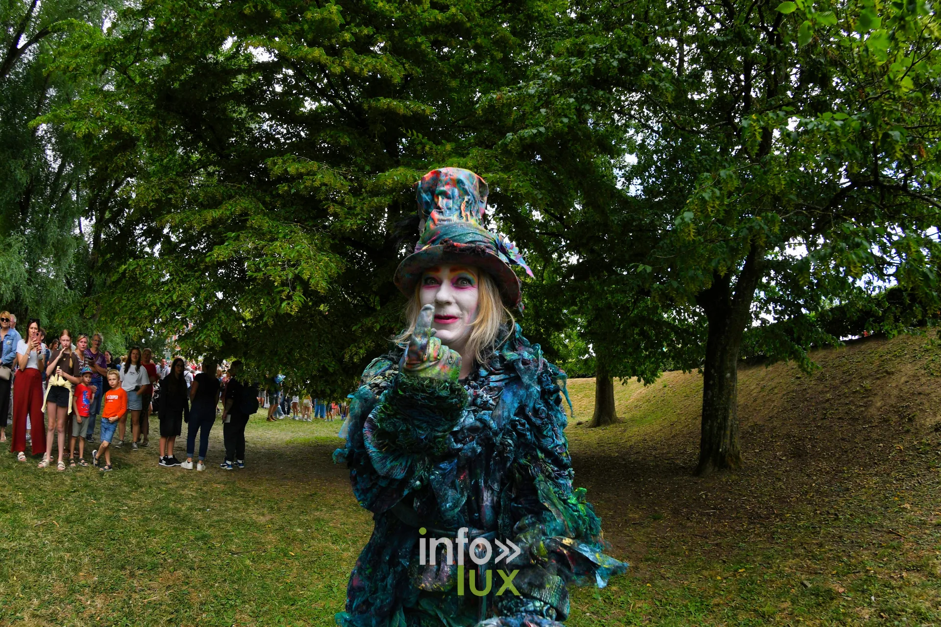 Statue vivante d'oiseau aux plumes vertes dans le parc lors des Statues en Marche 2026