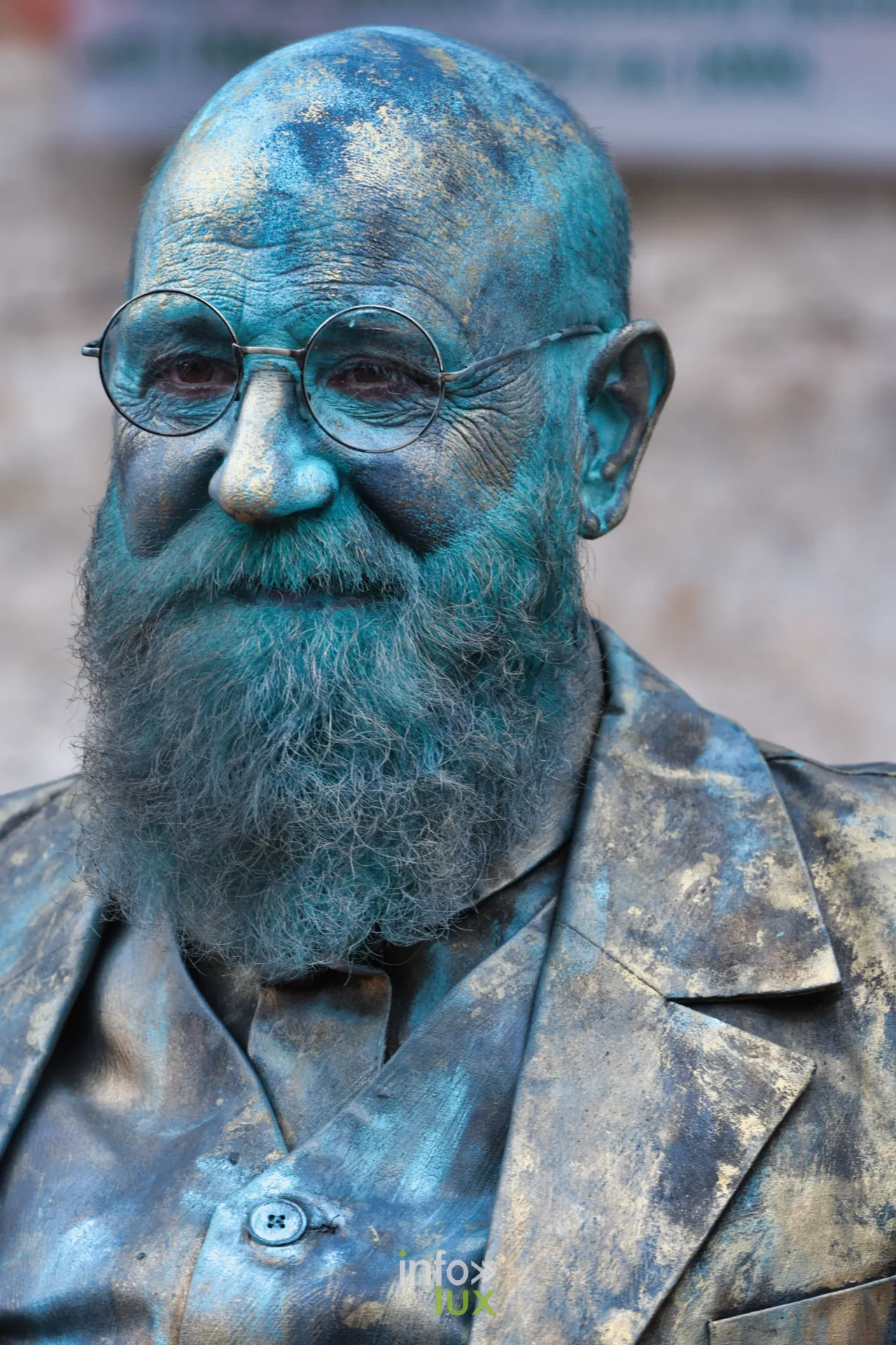 Portrait d'une statue vivante barbue à la patine bleu-vert aux Statues en Marche 2026