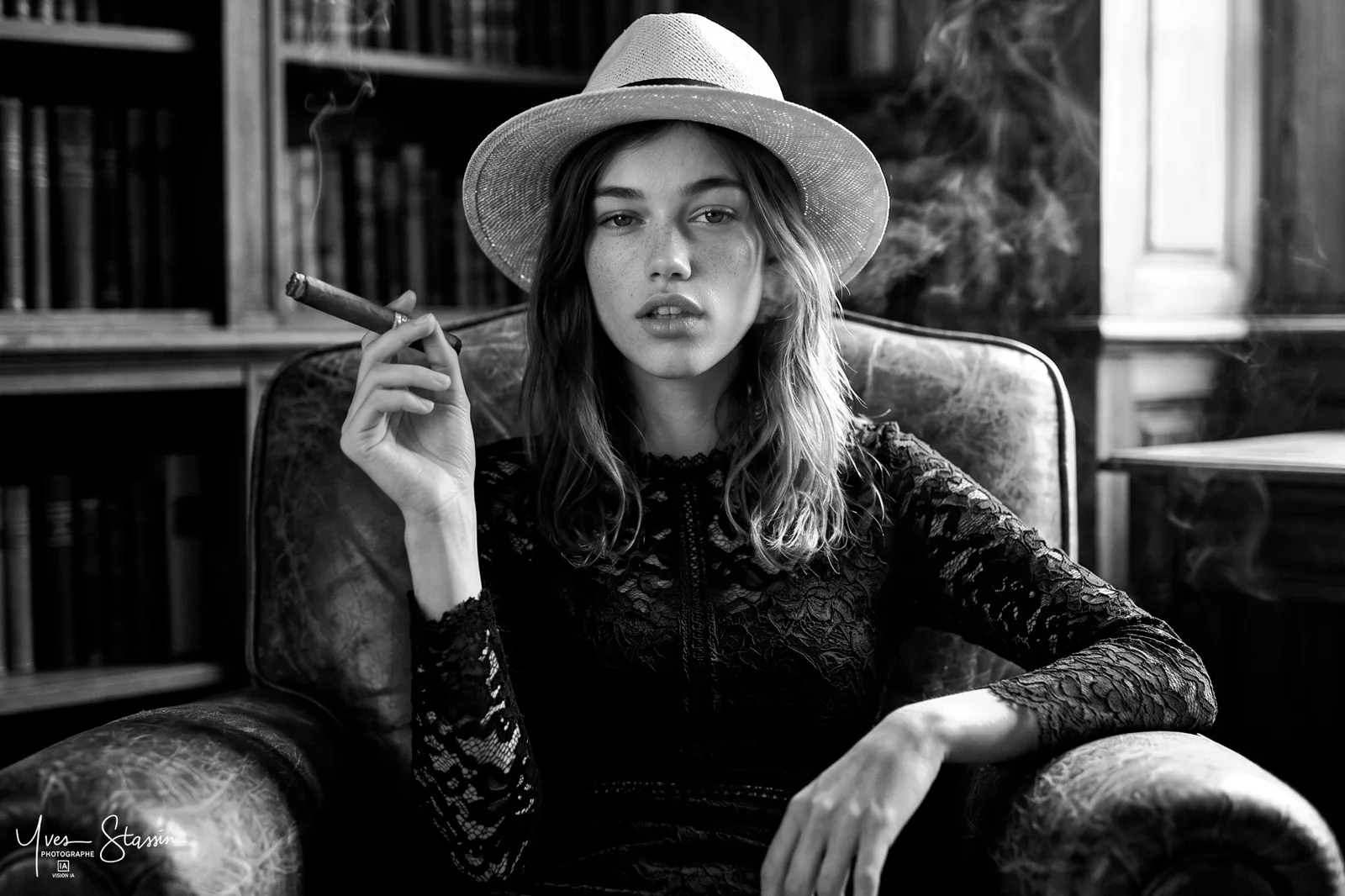 Portrait noir et blanc d'une jeune femme au chapeau, cigarette à la main
