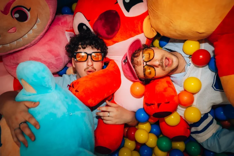 Nino et Antonin, le duo Bleu Soleil, allongés dans une piscine à balles entourés de peluches