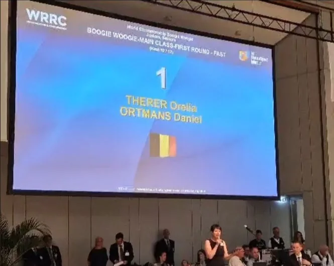 Ecran WRRC affichant THERER Orelia et ORTMANS Daniel sous le drapeau belge a Stuttgart
