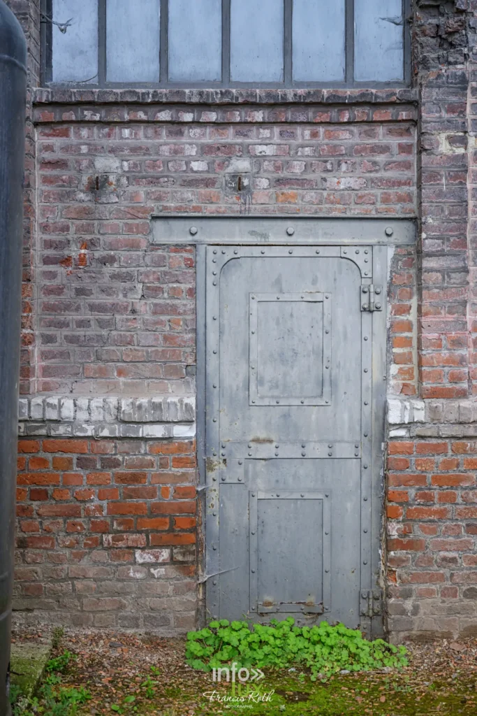 Porte de bois dans un mur de brique du site minier de Lewarde