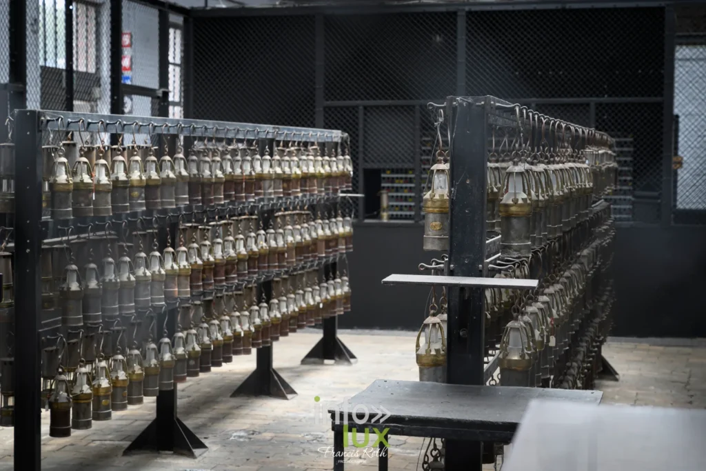 Rangées de lampes de mineurs alignées dans la lampisterie du musée
