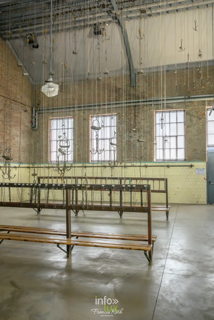 Salle aux bancs de bois alignés dans un bâtiment de la fosse Delloye