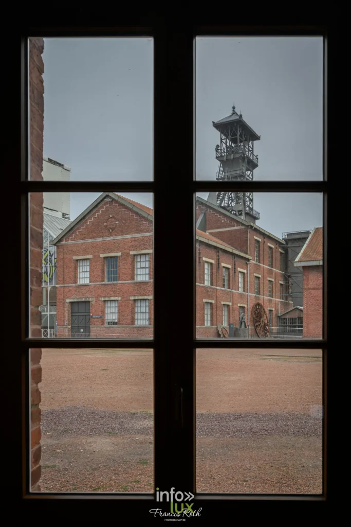Vue du chevalement de la fosse Delloye à travers les carreaux d'une fenêtre