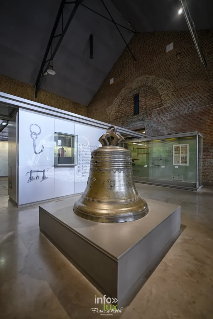 Cloche de mine exposée sur un socle dans une salle du musée