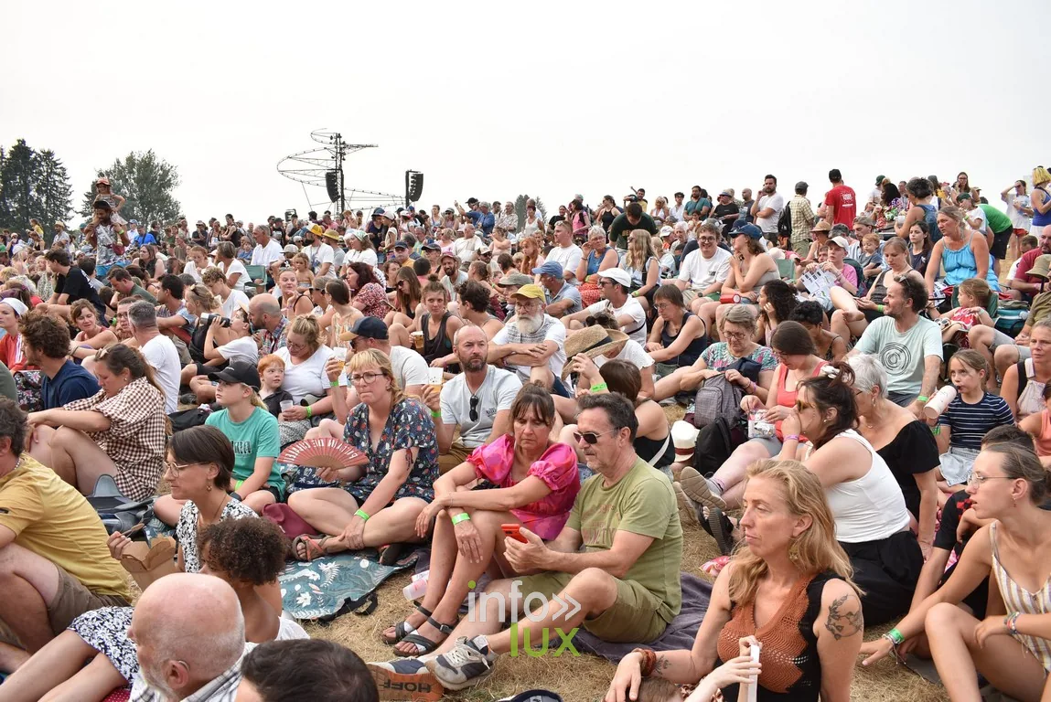 Assis dans l’herbe, le public attend le début du spectacle suivant.