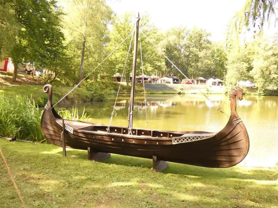Un drakkar en bois installé au bord de l’étang du parc Saint-Roch à Ciney pendant les Valhalla Days