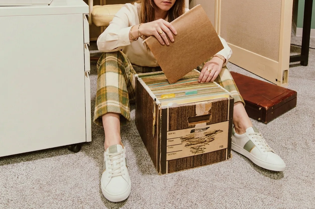 Femme triant des archives et des cartons conserves depuis des annees