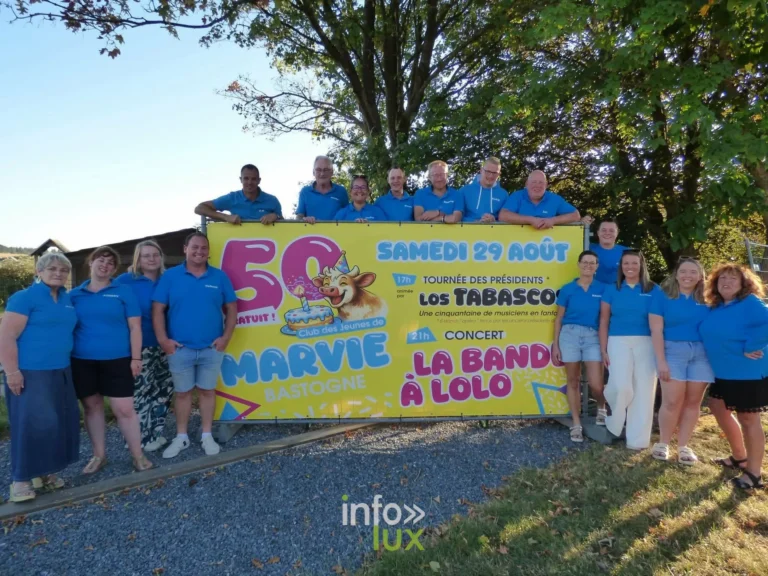 Les membres du Club des Jeunes de Marvie devant la banderole des 50 ans, à Bastogne
