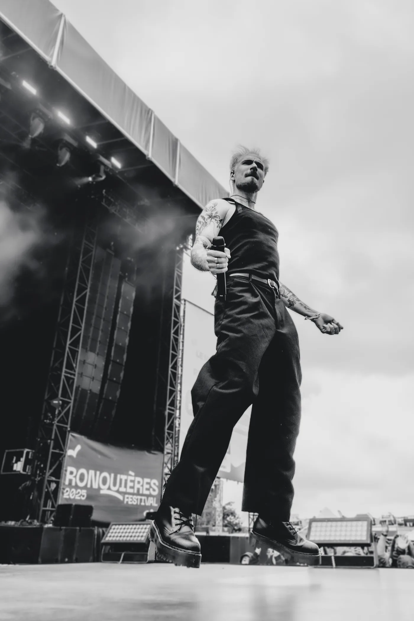 Doowy sur la scene du Ronquieres Festival, micro a la main, vue en contre-plongee