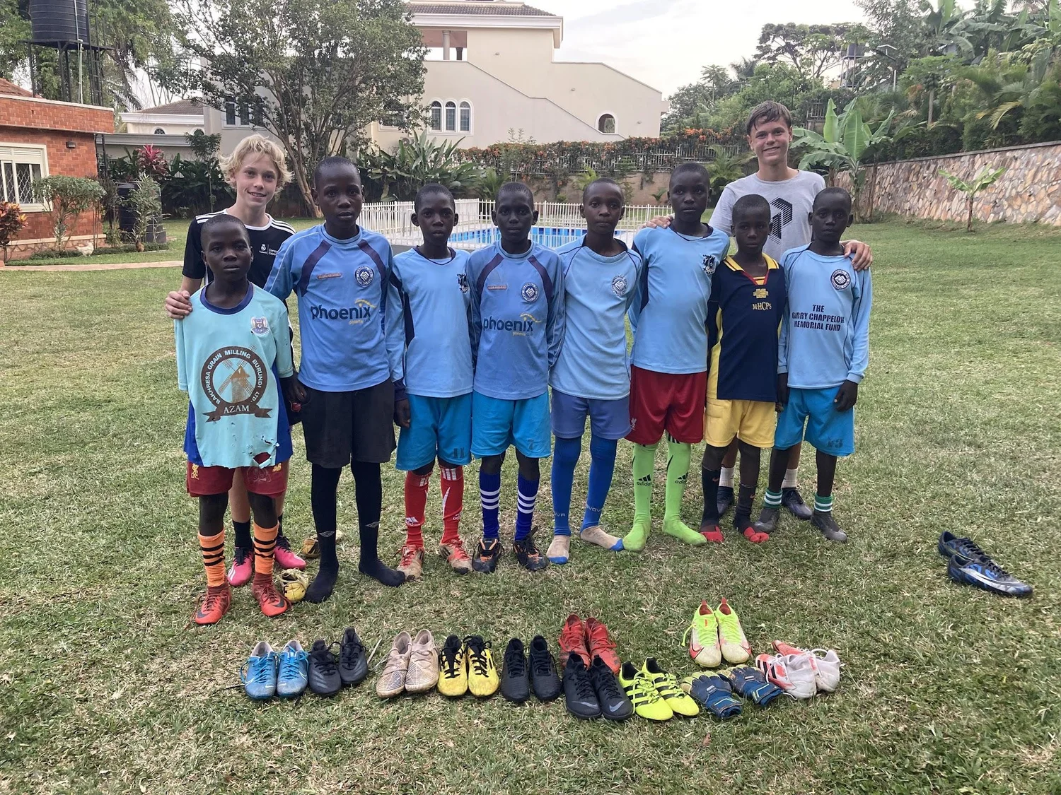 Les enfants ougandais et les chaussures recues Enfants ougandais posant avec les chaussures de football recues