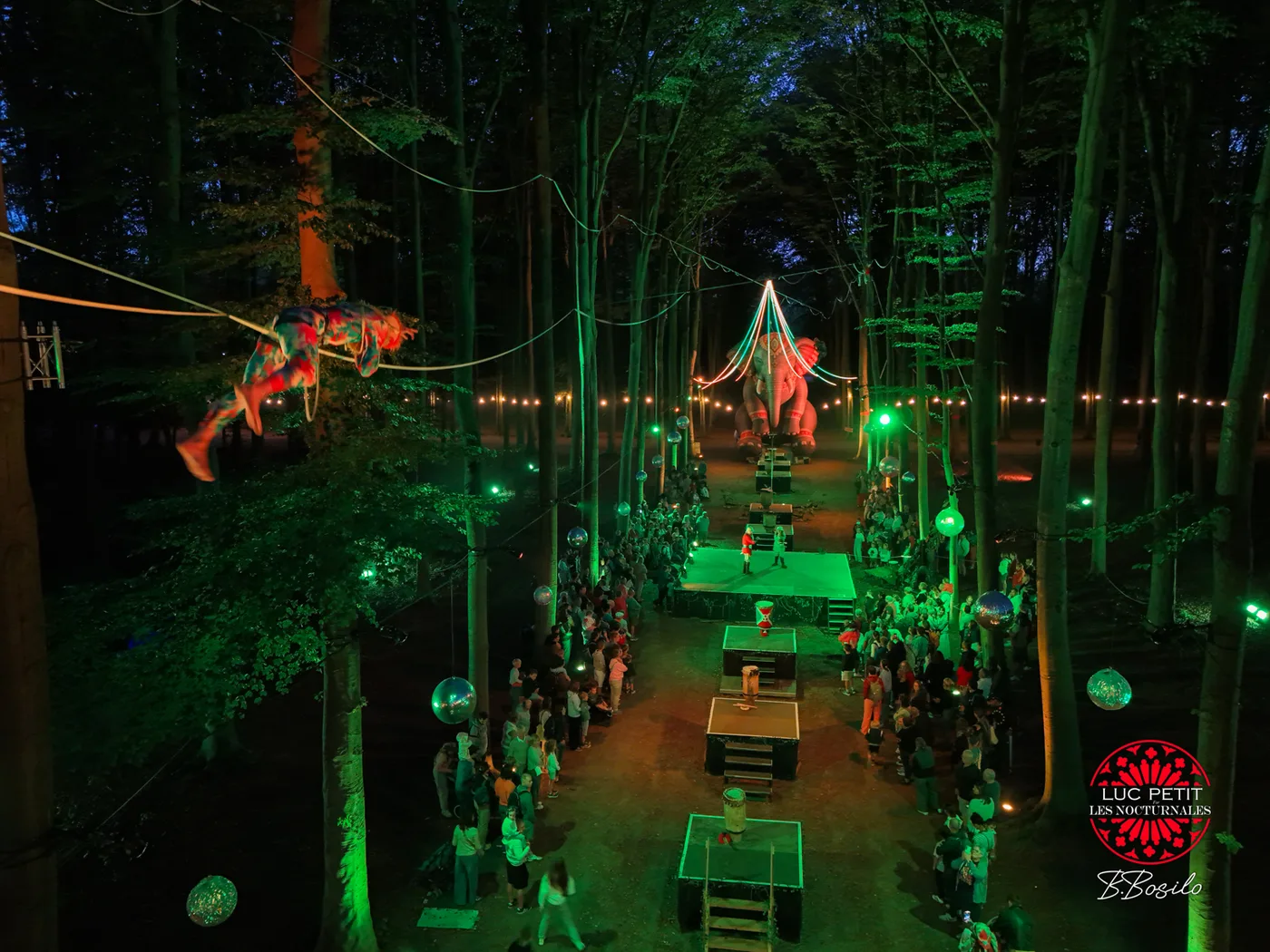 Acrobates aeriens dans la foret illuminee en vert lors du Livre de la Jungle a Beloeil