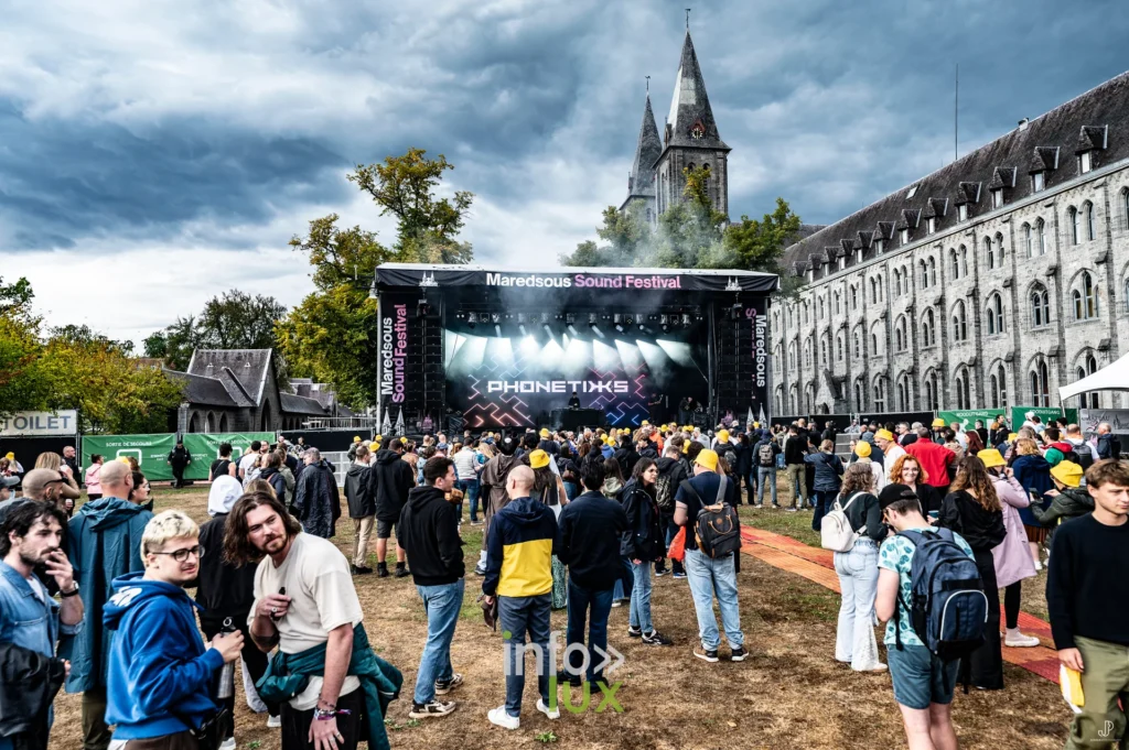 Le public devant la scène du Maredsous Sound Festival, le clocher de l'abbaye en arrière-plan
