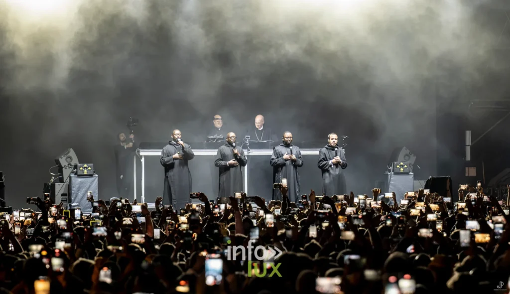 Vue depuis la scène : la foule du festival, des centaines de téléphones allumés face aux artistes
