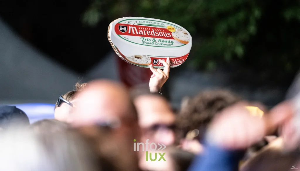 Une boîte de fromage de Maredsous brandie au-dessus de la foule du festival