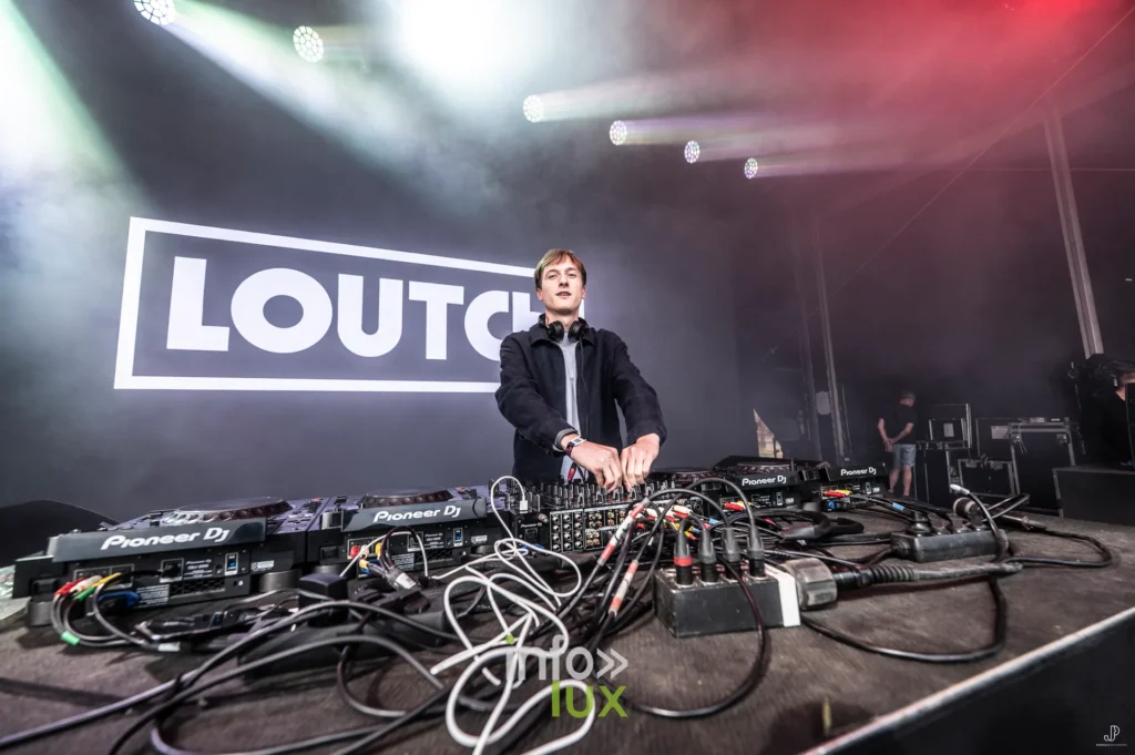 Loutch derrière ses platines Pioneer, éclairé de rouge et de blanc, au Maredsous Sound Festival