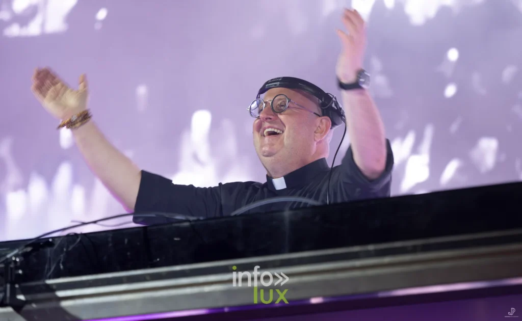 Padre Guilherme, bras ouverts et sourire aux lèvres, face au public du festival