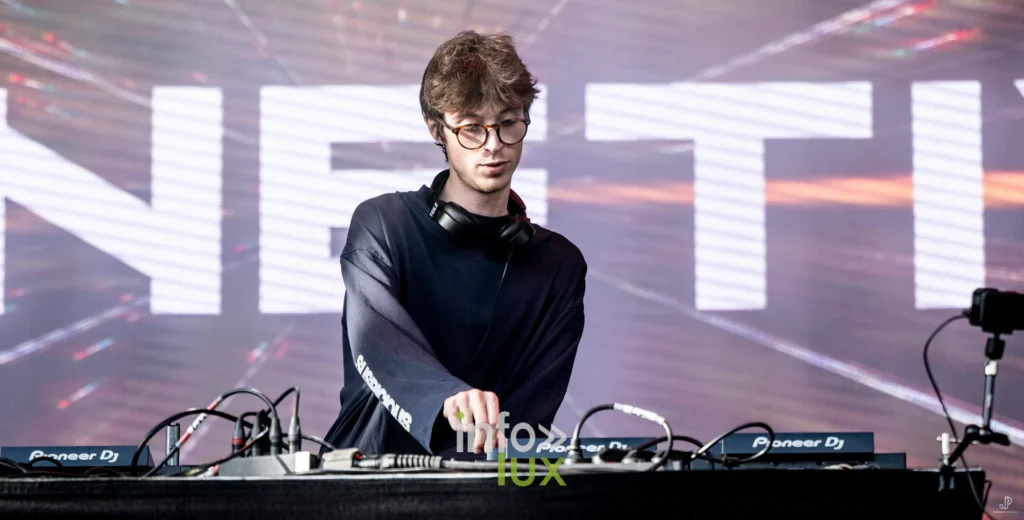 Un DJ de Phonetixs aux platines devant l'écran géant portant le nom du groupe