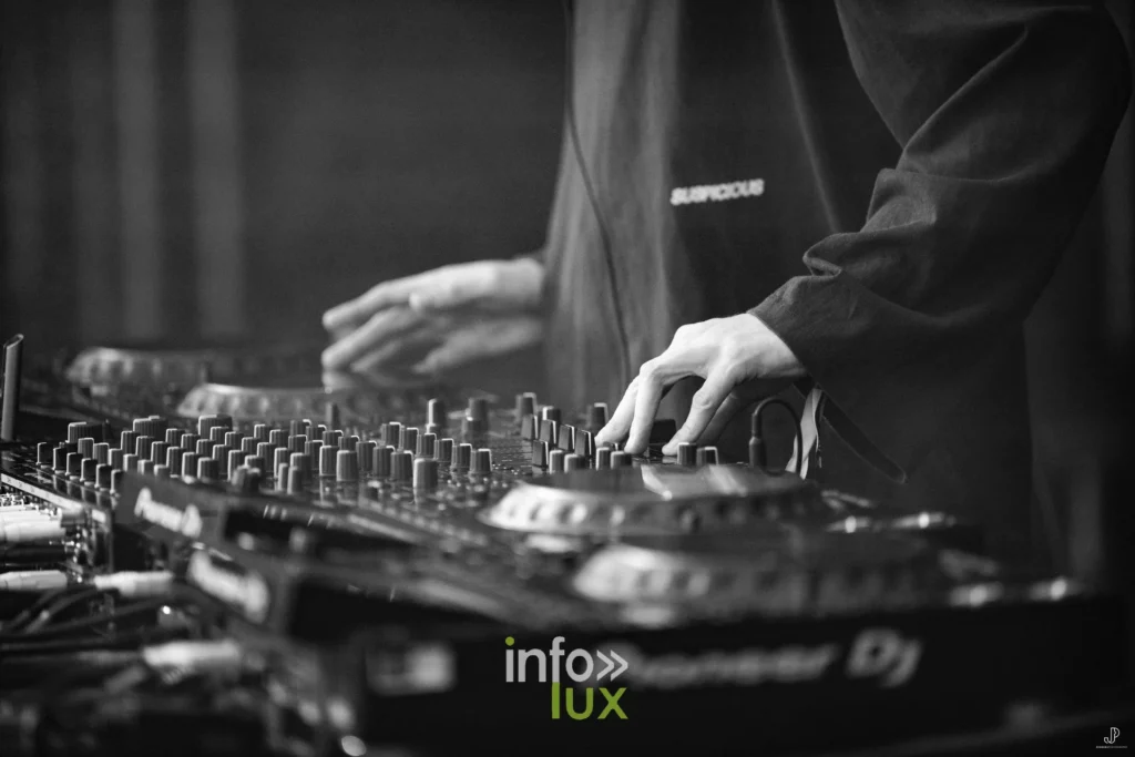 Vue rapprochée en noir et blanc d'une table de mixage Pioneer DJ et des mains du DJ