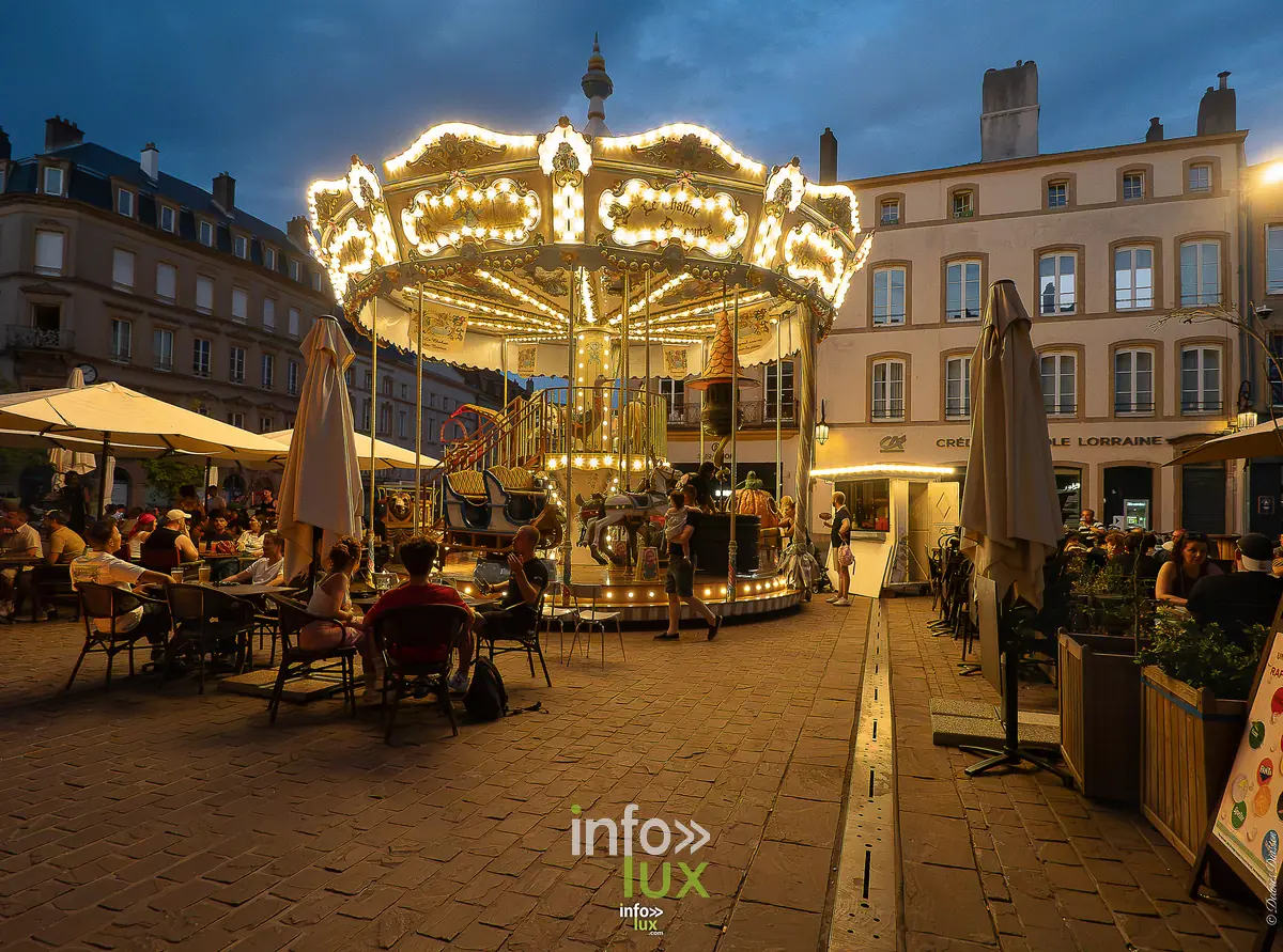 Metz, 15 août 2026 — Le carrousel, en fin de soirée : Metz ne s’éteint pas avec le jour.