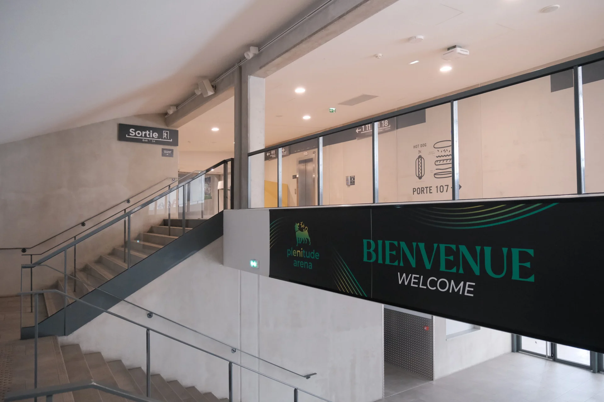 Une coursive intérieure de la Plenitude Arena, avec la signalétique des portes