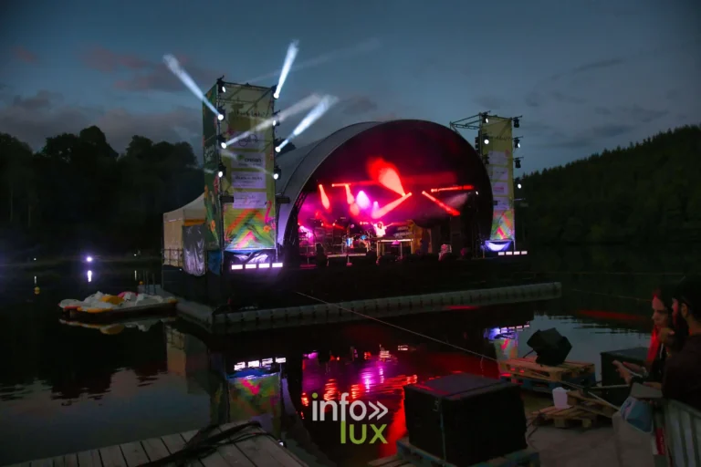 Scène flottante du Summer Lake Festival 2026 illuminée et reflétée sur le lac de Neufchâteau