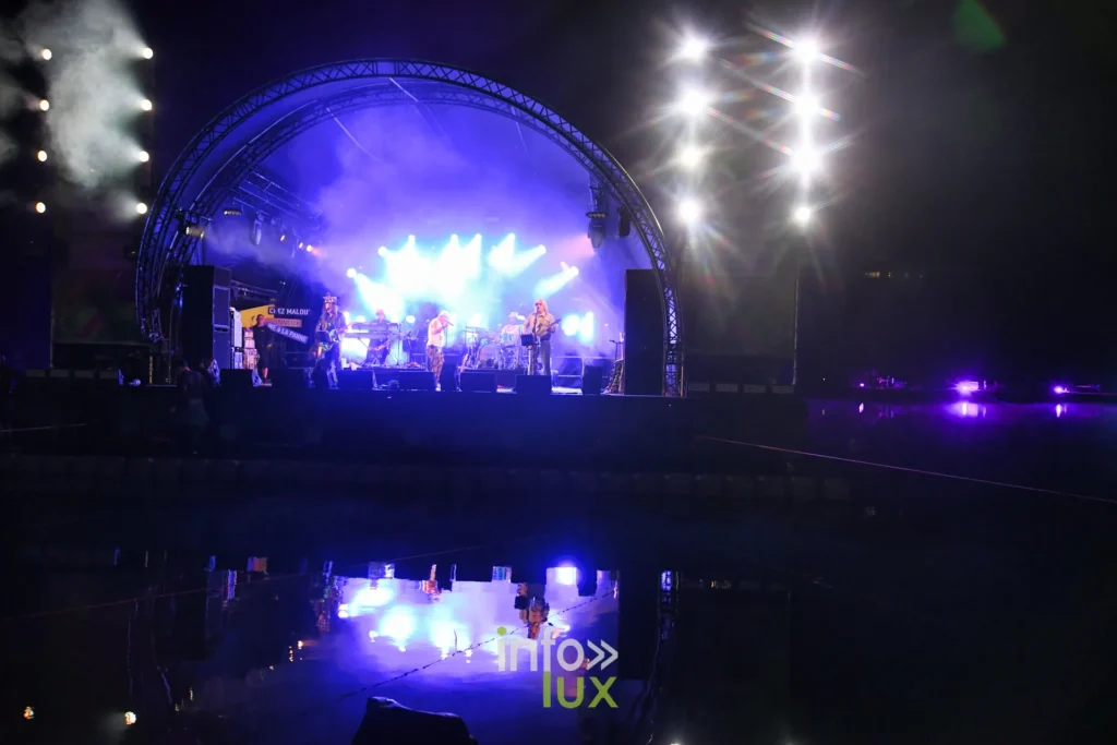 Scène flottante du Summer Lake Festival 2026 illuminée de nuit sur le lac de Neufchâteau