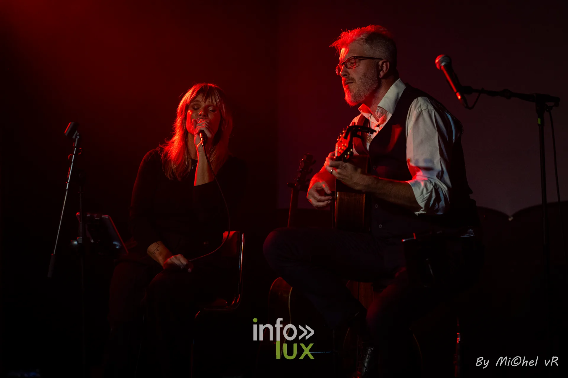 Julie Compagnon et Antoine Goudeseune assis sur scene, baignes dans une lumiere rouge