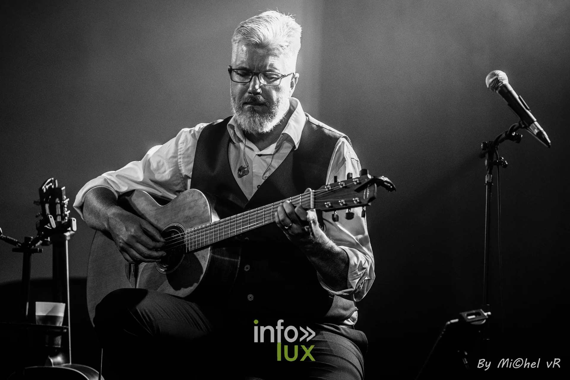 Gros plan en noir et blanc d'Antoine Goudeseune concentre sur sa guitare acoustique