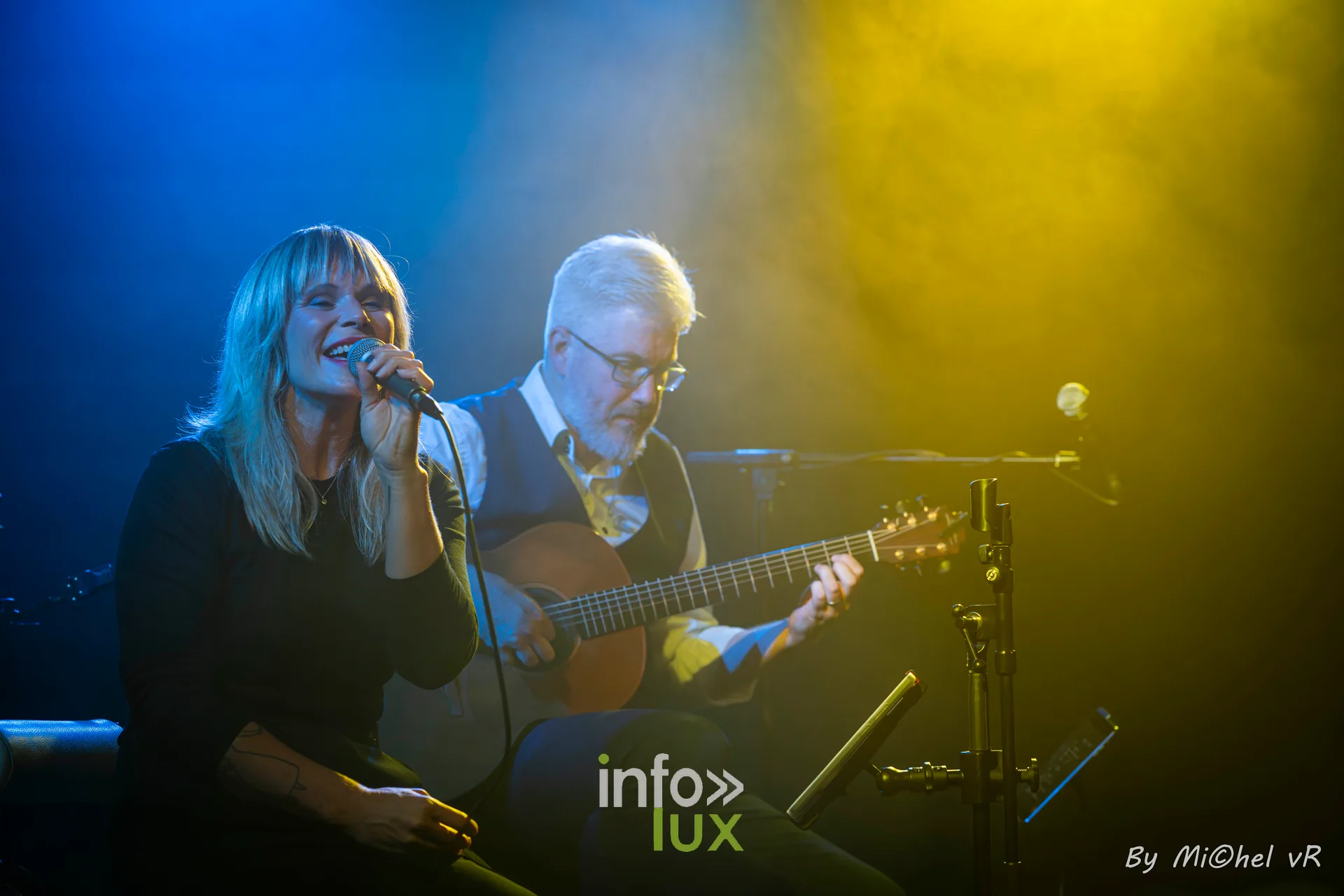 Julie Compagnon chante et Antoine Goudeseune joue de la guitare a contre-jour, entre lumiere jaune et bleue