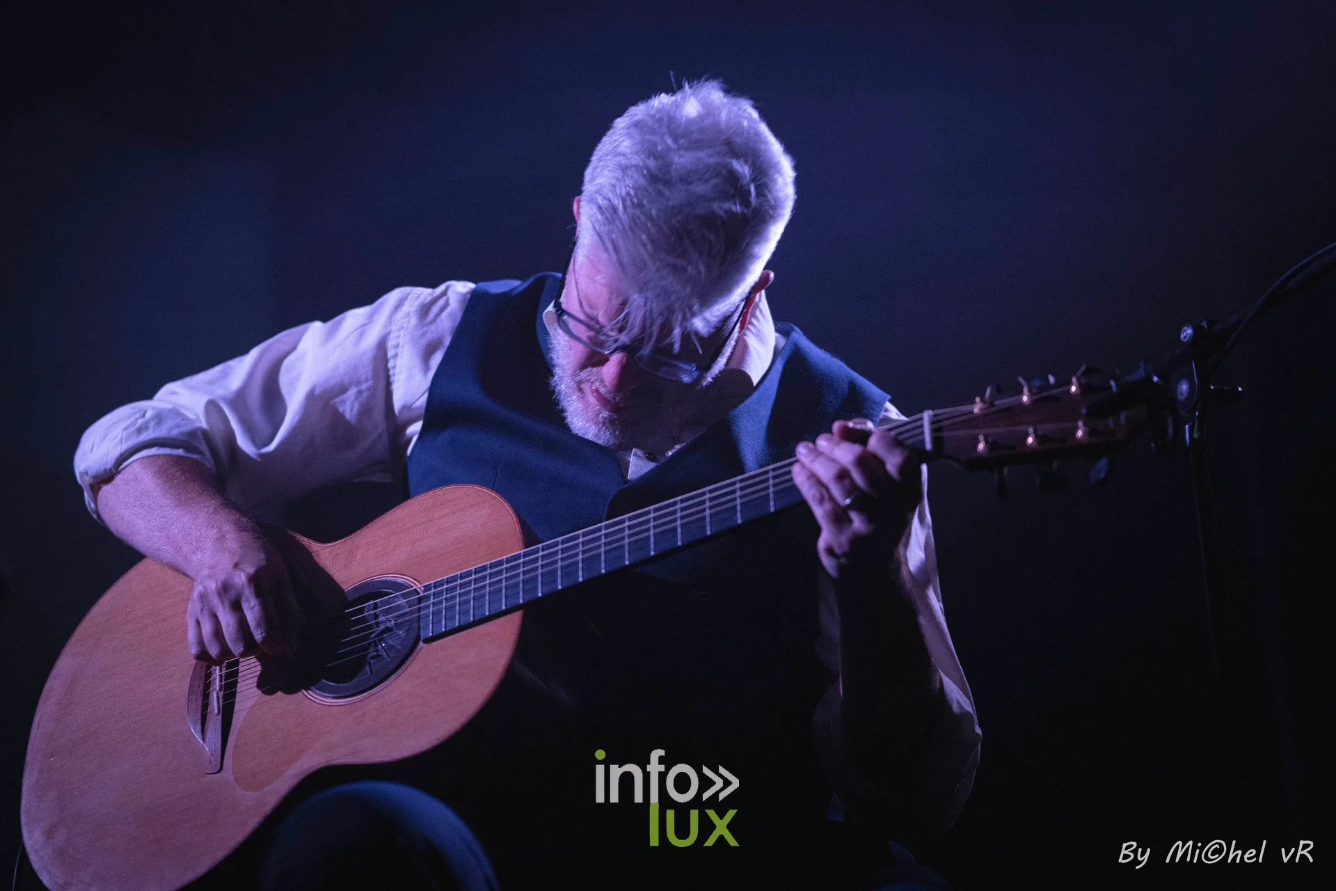 Antoine Goudeseune penche sur sa guitare, dans une lumiere sombre