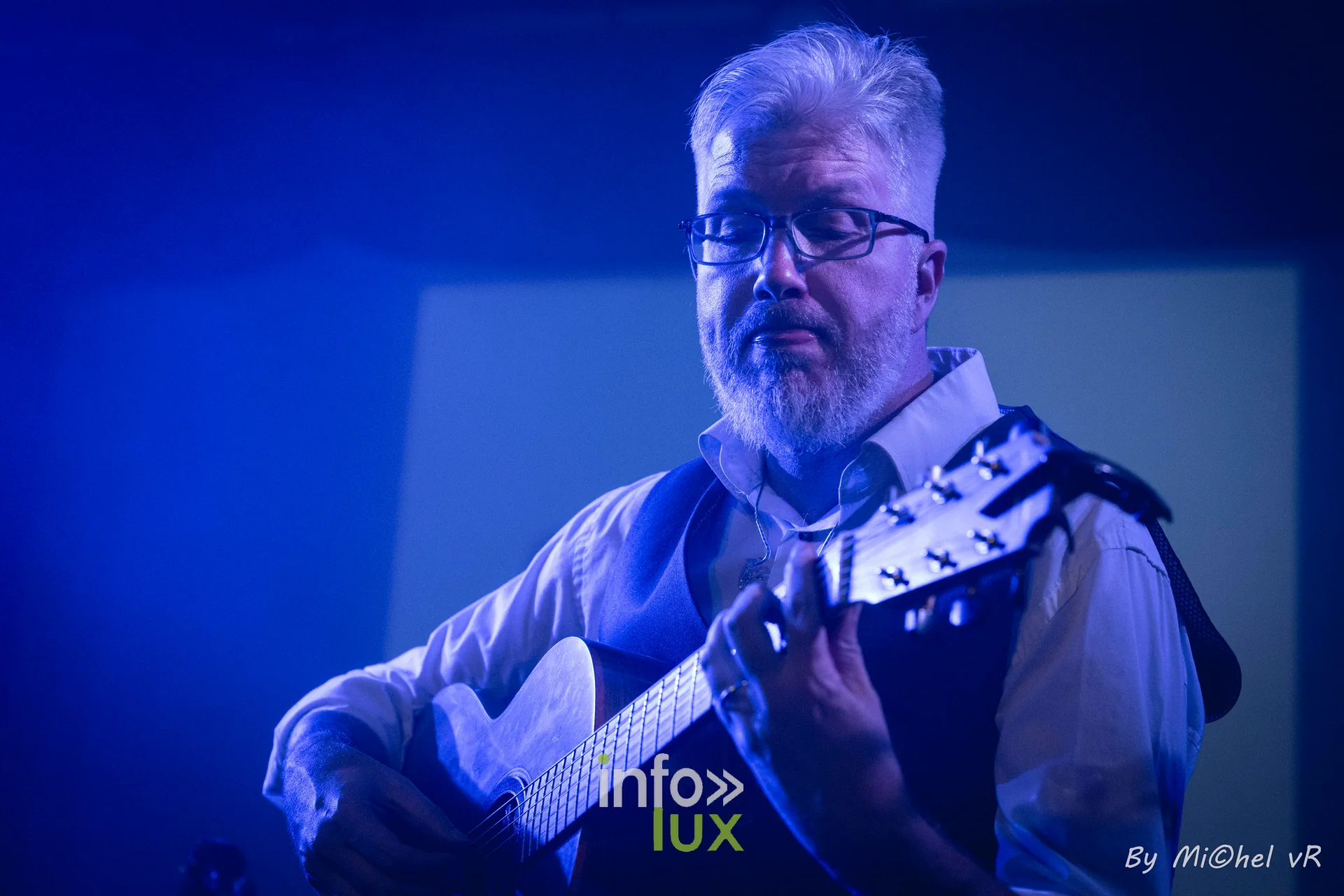 Antoine Goudeseune joue de la guitare sous une lumiere bleue, en gros plan