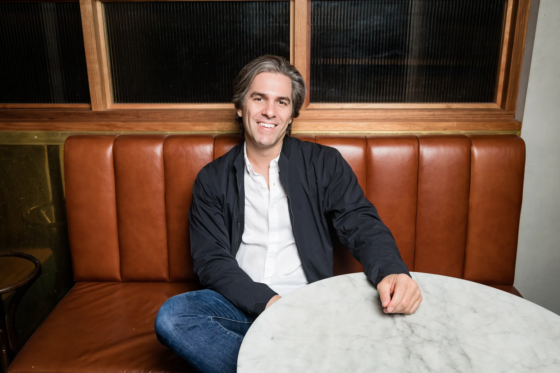 Adam Wilkes, PDG d’AEG Presents Europe et Asie-Pacifique, assis sur une banquette en cuir