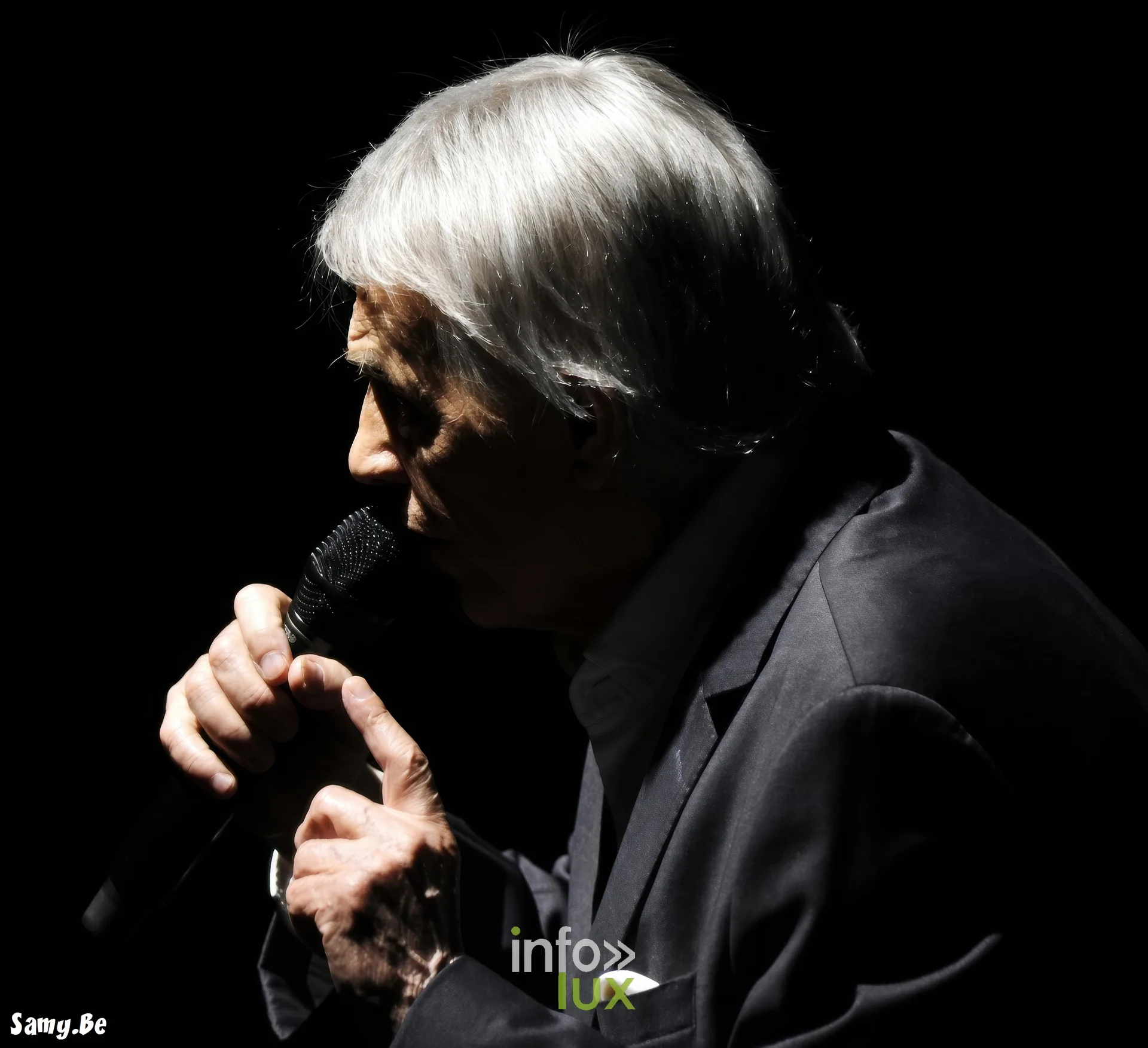 Salvatore Adamo au micro en contre-jour – concert de Salvatore Adamo, Fêtes de Wallonie 2026, Grand-Place de Mons