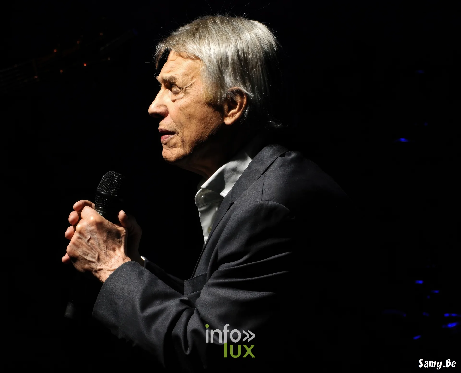 Salvatore Adamo de profil, micro tenu à deux mains – concert de Salvatore Adamo, Fêtes de Wallonie 2026, Grand-Place de Mons