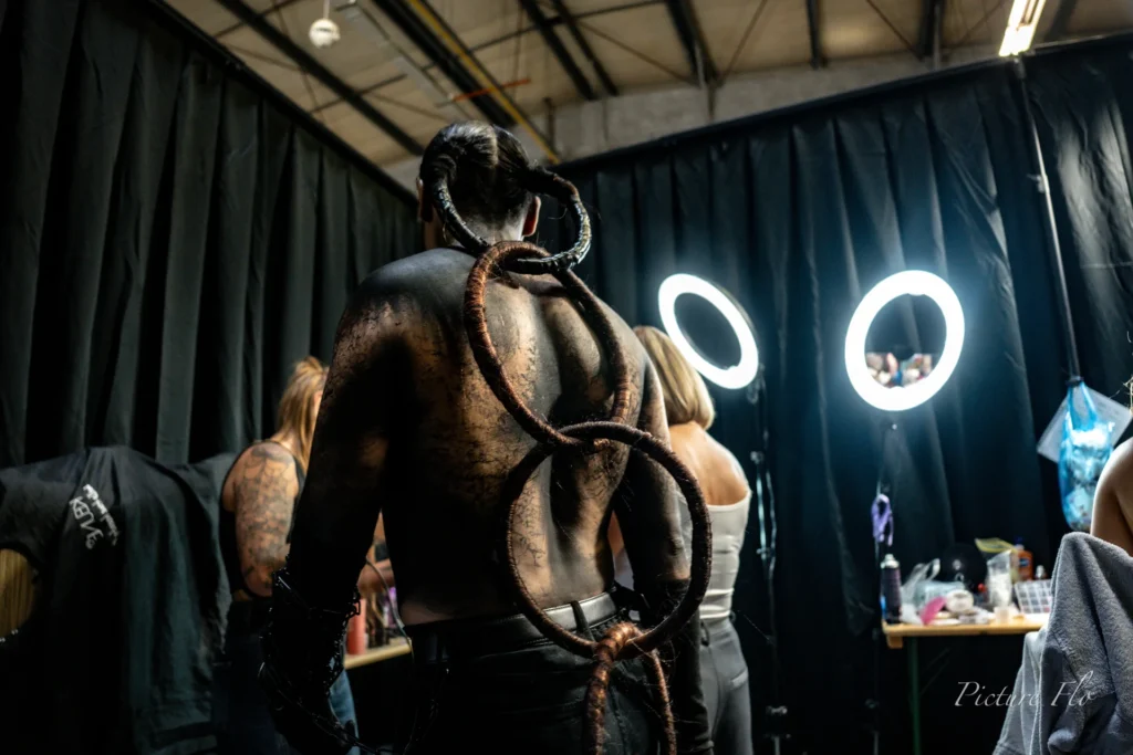Youness de dos, anneaux en cheveux sur le dos maquillé, coulisses de la Lux Fashion Week 2026, Arlon